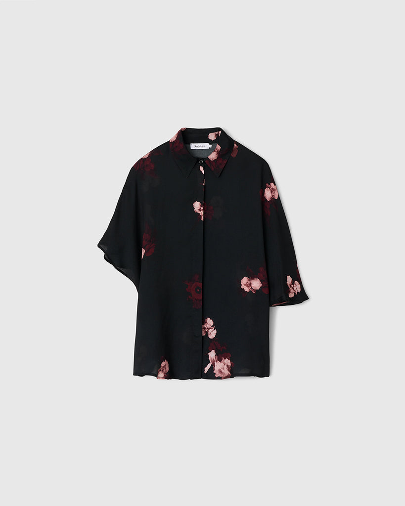 Zwiewna, koszulowa bluzka Finch Wine Black w kolorze czarnym z kwiatowym printem. Posiada klasyczny kołnierzyk i asymetryczne rękawy. Zapinana jest na ukryte guziki. Stwórz idealny set ze spodniami Ezra tej samej marki.&nbsp;