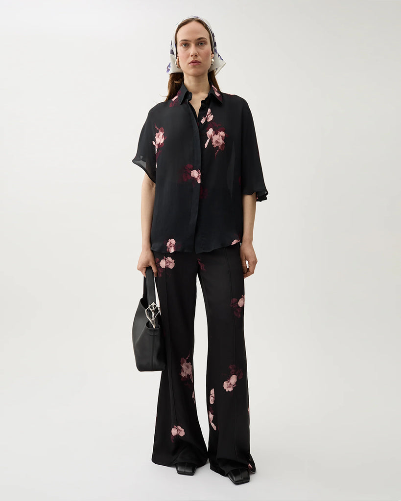 Zwiewna, koszulowa bluzka Finch Wine Black w kolorze czarnym z kwiatowym printem. Posiada klasyczny kołnierzyk i asymetryczne rękawy. Zapinana jest na ukryte guziki. Stwórz idealny set ze spodniami Ezra tej samej marki.&nbsp;