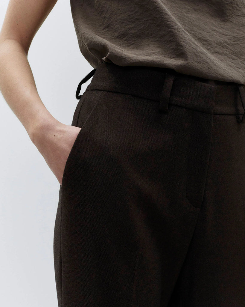 Spodnie dzwony Flare Lana Choco o regularnym kroju z wysokim stanem. Posiadają szlufki na pasek, kieszenie boczne z przodu i tylne kieszenie z patką zapinane na guziki. Wykonane z mieszanki z wiskozą i wełną. Zapinane na kryty zamek błyskawiczny i haftkę.&nbsp;