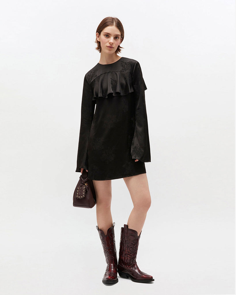 Prosta, mini sukienka 0792 GANNI Satin Black w kwiatowy print, z okrągłym dekoltem i szerokimi, długimi rękawami. Sukienka ma falbankę przy dekolcie i odkryte plecy z wiązaniem na sznurek. Wykonana z połyskliwej tkaniny.