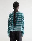 Luźny, skrócony T-shirt Franto Stripe-B marki BELLEROSE z okrągłym dekoltem i długimi rękawami w ciemnozielonym kolorze z kolorowymi paskami. Wykończony kontrastowym, spranym, zielonym ściagaczem przy kołnierzyku i mankietach. Wykonany z bawełny.

-Luźny, skrócony krój

-Wybierz swój zwykły rozmiar lub mniejszy, aby uzyskać bardziej dopasowany look