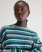 Luźny, skrócony T-shirt Franto Stripe-B marki BELLEROSE z okrągłym dekoltem i długimi rękawami w ciemnozielonym kolorze z kolorowymi paskami. Wykończony kontrastowym, spranym, zielonym ściagaczem przy kołnierzyku i mankietach. Wykonany z bawełny.

-Luźny, skrócony krój

-Wybierz swój zwykły rozmiar lub mniejszy, aby uzyskać bardziej dopasowany look