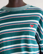 Luźny, skrócony T-shirt Franto Stripe-B marki BELLEROSE z okrągłym dekoltem i długimi rękawami w ciemnozielonym kolorze z kolorowymi paskami. Wykończony kontrastowym, spranym, zielonym ściagaczem przy kołnierzyku i mankietach. Wykonany z bawełny.

-Luźny, skrócony krój

-Wybierz swój zwykły rozmiar lub mniejszy, aby uzyskać bardziej dopasowany look