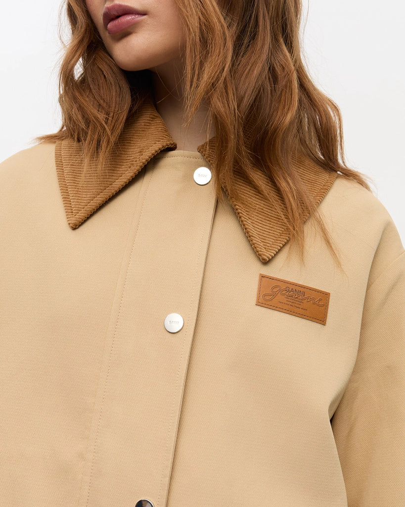 Oversiziowa, przejściowa kurtka 0757 GANNI w stylu worker. Posiada duży kołnierzyk obszyty sztruksem oraz luźne, długie rękawy. Z przodu kurtka ma dwie, duże, prostokątne kieszenie z klapkami. Zapinana na zatrzaskowe guziki i zamek błyskawiczny