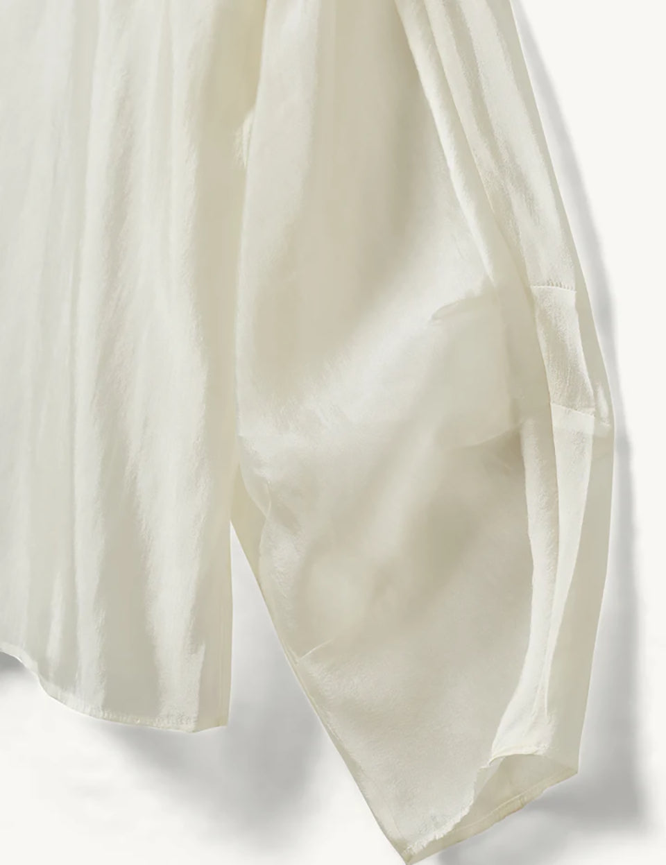 Luźna, kremowa bluzka Gilian Cream marki The Garment z okrągłym dekoltem i szerokimi rękawami o obniżonej linii ramion, zakończone mankietami. Z tyłu widoczne jest eleganckie wycięcie w kształcie łezki, zapinane na guzik. Bluzka wykonana jest z bardzo cienkiego, półtransparentnego materiału o delikatnym połysku.&nbsp;

-Luźny krój

-Cienki materiał o delikatnym połysku

-Zamów bluzkę w swoim standardowym rozmiarze&nbsp;
