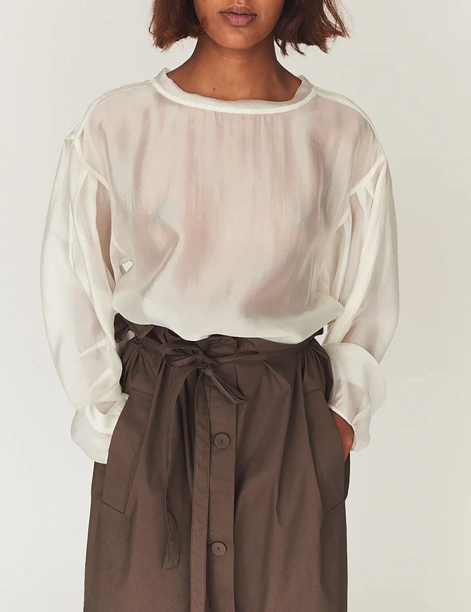 Luźna, kremowa bluzka Gilian Cream marki The Garment z okrągłym dekoltem i szerokimi rękawami o obniżonej linii ramion, zakończone mankietami. Z tyłu widoczne jest eleganckie wycięcie w kształcie łezki, zapinane na guzik. Bluzka wykonana jest z bardzo cienkiego, półtransparentnego materiału o delikatnym połysku.&nbsp;

-Luźny krój

-Cienki materiał o delikatnym połysku

-Zamów bluzkę w swoim standardowym rozmiarze&nbsp;