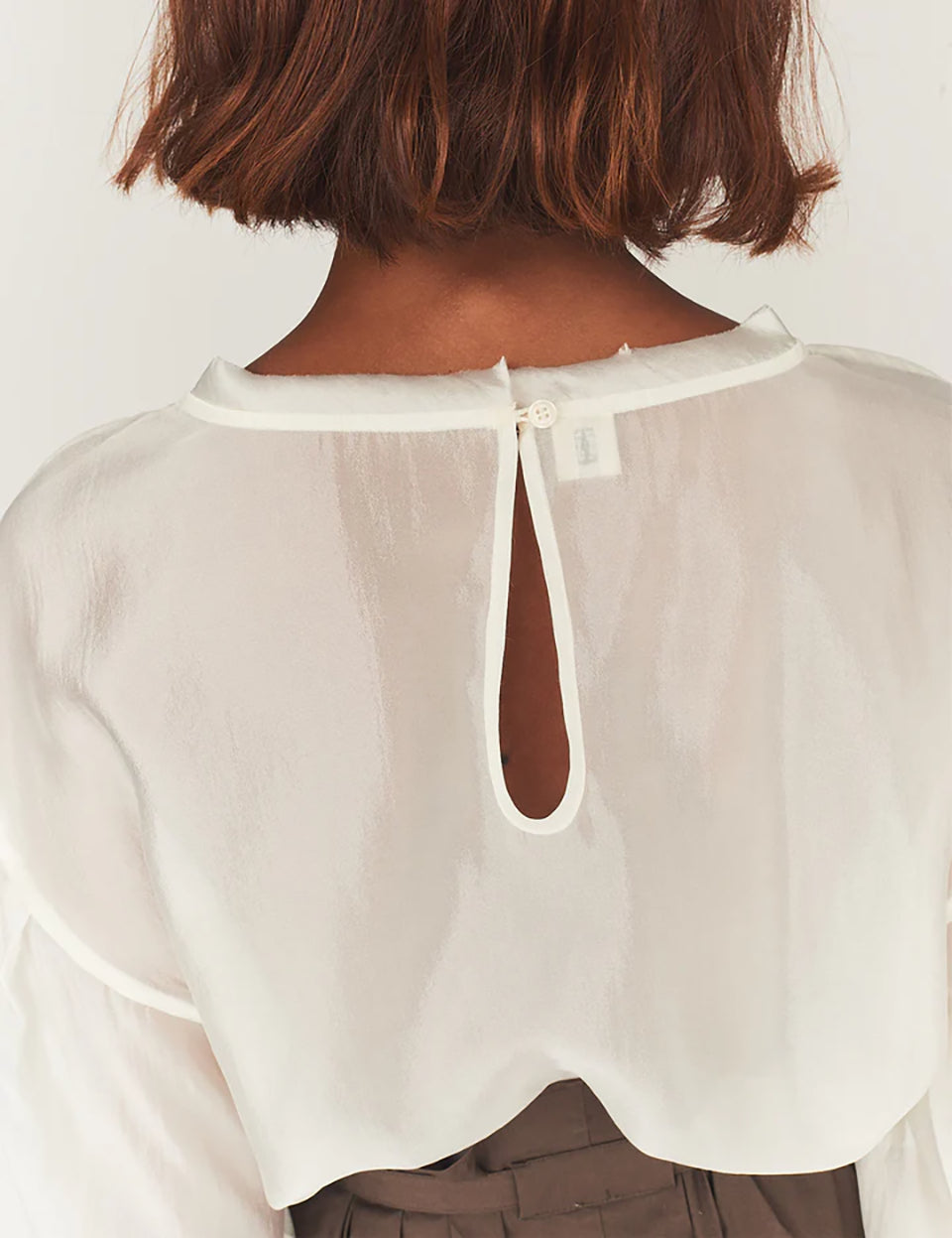 Luźna, kremowa bluzka Gilian Cream marki The Garment z okrągłym dekoltem i szerokimi rękawami o obniżonej linii ramion, zakończone mankietami. Z tyłu widoczne jest eleganckie wycięcie w kształcie łezki, zapinane na guzik. Bluzka wykonana jest z bardzo cienkiego, półtransparentnego materiału o delikatnym połysku.&nbsp;

-Luźny krój

-Cienki materiał o delikatnym połysku

-Zamów bluzkę w swoim standardowym rozmiarze&nbsp;