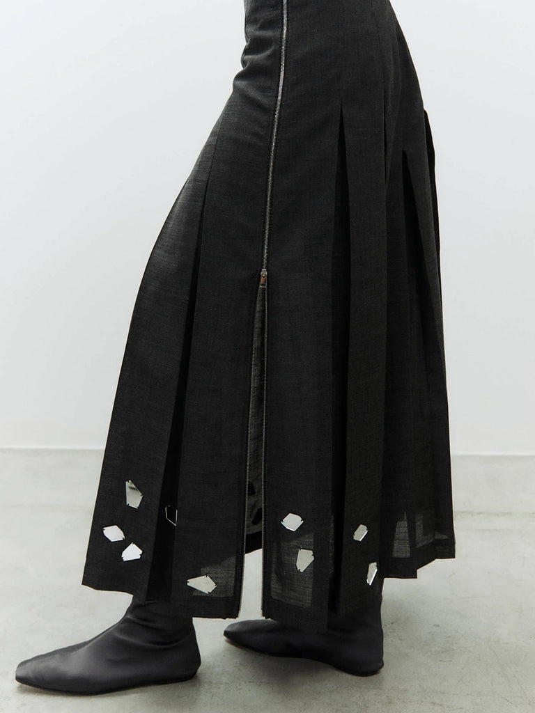 Długa, plisowana spódnica Gonna Carbone z rozkloszowanym dołem i dopasowaną talią z wysokim stanem. U dołu zdobiona jest ręcznie wyszywanym haftem. Zapinana z boku na zamek błyskawiczny. Wykonana jest z mieszanki z wełną.&nbsp;