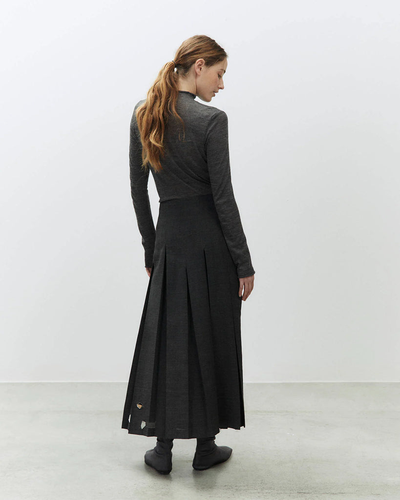 Długa, plisowana spódnica Gonna Carbone z rozkloszowanym dołem i dopasowaną talią z wysokim stanem. U dołu zdobiona jest ręcznie wyszywanym haftem. Zapinana z boku na zamek błyskawiczny. Wykonana jest z mieszanki z wełną.&nbsp;