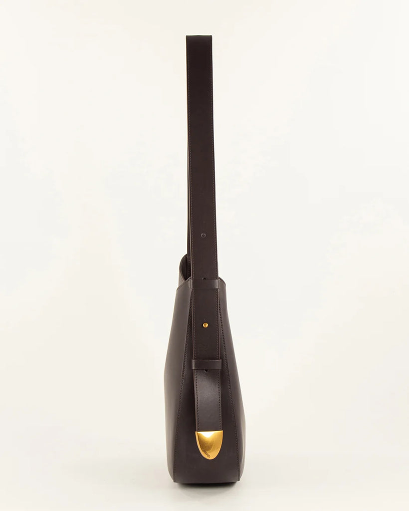 Brązowa, skórzana torba Grandę Amo Deep Coffea francuskiej marki Sessun z regulowanym paskiem na ramię. Pasek ma metalowe zakończenie z grawerunkiem marki. Torba ma jedną, centralną komorę z wewnętrzną kieszenią zapinaną na zamek. Zapinana na zatrzask.&nbsp;