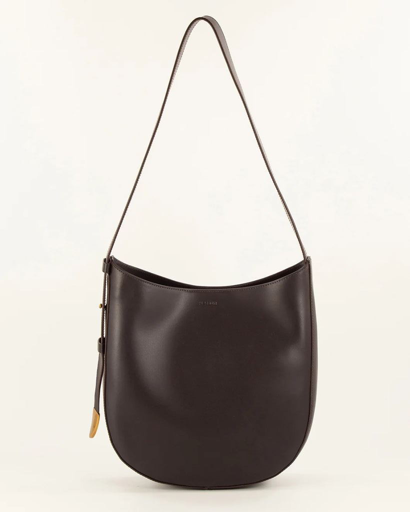 Brązowa, skórzana torba Grandę Amo Deep Coffea francuskiej marki Sessun z regulowanym paskiem na ramię. Pasek ma metalowe zakończenie z grawerunkiem marki. Torba ma jedną, centralną komorę z wewnętrzną kieszenią zapinaną na zamek. Zapinana na zatrzask.&nbsp;