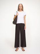 Eleganckie, lekkie spodnie Gretana Black By Malene Birger z dopasowaną gumką w pasie i szerokimi nogawkami. Dół nogawek zdobią delikatne hafty angielskie dodające subtelnego, kobiecego charakteru. Wykonane z bawełny organicznej. Idealnie sprawdzą się do casualowych stylizacji.

-Luźny krój

-Delikatne hafty angielskie&nbsp;

-Zamów spodnie w rozmiarze, który zazwyczaj nosisz