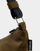 Mała torba typu sling w kolorze khaki Hane Carbone marki Bellerose o miękkiej, zaokrąglonej konstrukcji. Model wyposażony w zapięcie na zamek błyskawiczny; szeroki, regulowany pasek z taśmy, srebrne okucia i wewnętrzną kieszeń. Posiada podszewkę z lekkiego materiału technicznego.&nbsp;