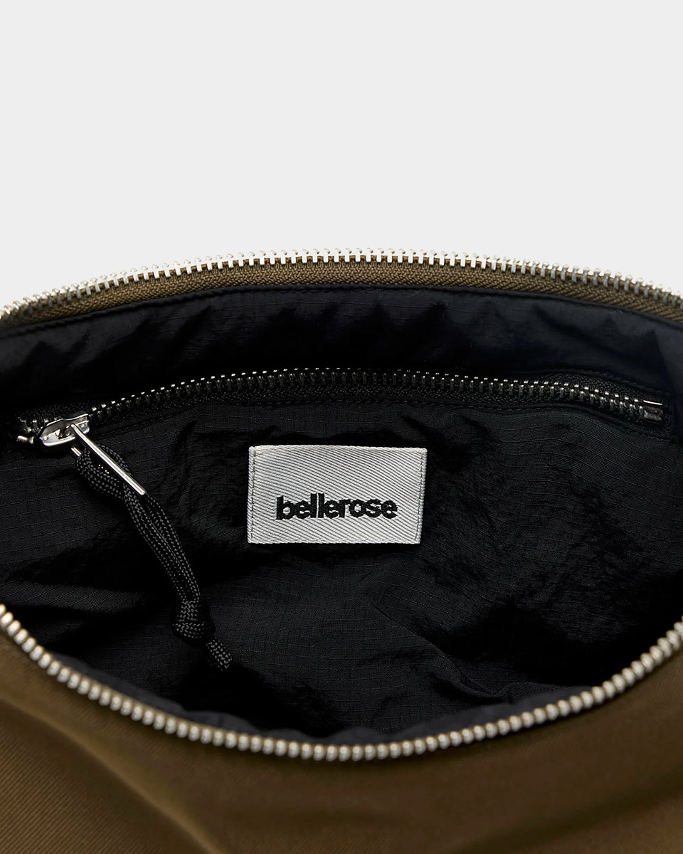 Mała torba typu sling w kolorze khaki Hane Carbone marki Bellerose o miękkiej, zaokrąglonej konstrukcji. Model wyposażony w zapięcie na zamek błyskawiczny; szeroki, regulowany pasek z taśmy, srebrne okucia i wewnętrzną kieszeń. Posiada podszewkę z lekkiego materiału technicznego.&nbsp;