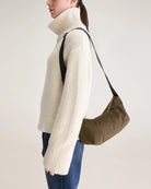 Mała torba typu sling w kolorze khaki Hane Carbone marki Bellerose o miękkiej, zaokrąglonej konstrukcji. Model wyposażony w zapięcie na zamek błyskawiczny; szeroki, regulowany pasek z taśmy, srebrne okucia i wewnętrzną kieszeń. Posiada podszewkę z lekkiego materiału technicznego.&nbsp;