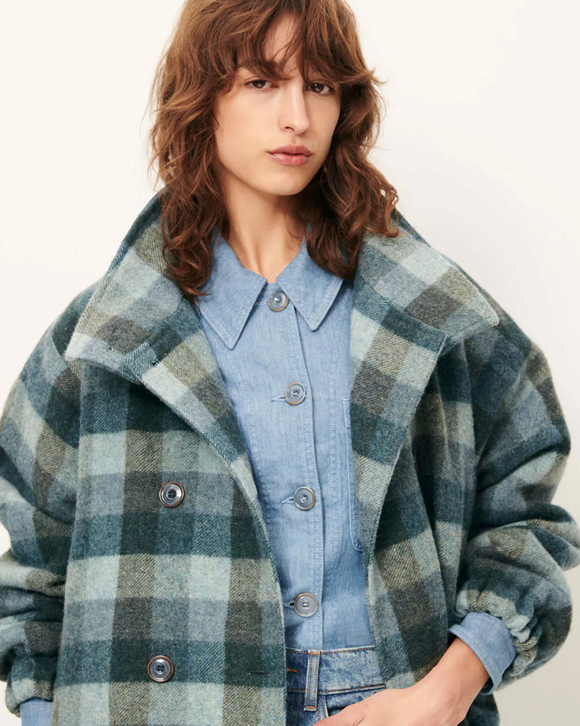 Krótki, elastyczny płaszcz Harlow Smocky Blue z miękkiej, puszystej wełny o podwójnym splocie w kratę, tkanej we Włoszech. Ma wysoki kołnierz z zapięciem na guzik, kieszenie z patką oraz ściągacz na dole i przy mankietach. Zapięcie dwurzędowe.&nbsp;