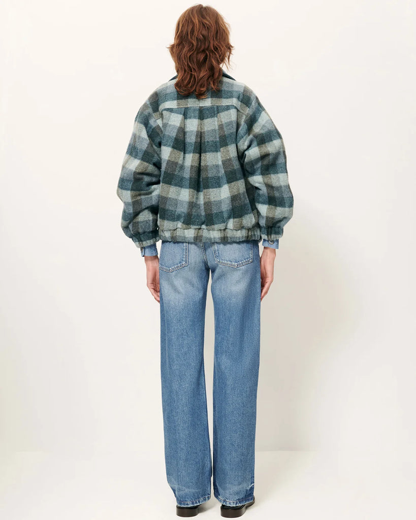 Krótki, elastyczny płaszcz Harlow Smocky Blue z miękkiej, puszystej wełny o podwójnym splocie w kratę, tkanej we Włoszech. Ma wysoki kołnierz z zapięciem na guzik, kieszenie z patką oraz ściągacz na dole i przy mankietach. Zapięcie dwurzędowe.&nbsp;