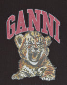 Oversizowy, ciemnoszary, bawełniany T-shirt Tiger Caviar GANNI Phantom z okrągłym dekoltem i krótkim, szerokim rękawem. Z przodu posiada kryształkową grafikę tygrysa oraz kryształkowe logo GANNI. Wykonany z grubej i miękkiej bawełny organicznej. Idealny z jeansami lub spódnicą.

-100% bawełna organiczna

-Fason OVERSIZE - jeśli chcesz uzyskać oversizowy efekt zamów koszulkę w swoim standardowym rozmiarze. Jeśli chcesz żeby był luźny, ale nieco bardziej przylegający - zamów go w mniejszym rozmiarze