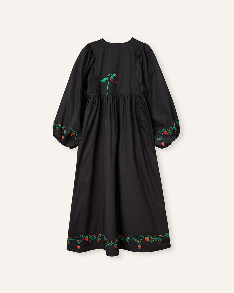 Oversizowa sukienka maxi Sigrid HELMSTEDT w uroczy haft z motywem truskawek. Sukienka ma rozszerzane, długie rękawy i okrągły dekolt z trójkątnym wycięciem i wiązaniem. Jest odcięta pod biustem. Sukienka ma długość do kostek. 