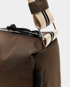 Zapinana na suwak torebka typu cross body Hobbes Dark Roast marki Bellerose z brązowego, matowego nylonu o fakturowanej powierzchni. Wyróżnia się prostokątnym kształtem, miękką konstrukcją oraz regulowanym paskiem w paski i silikonowym logo.&nbsp;
