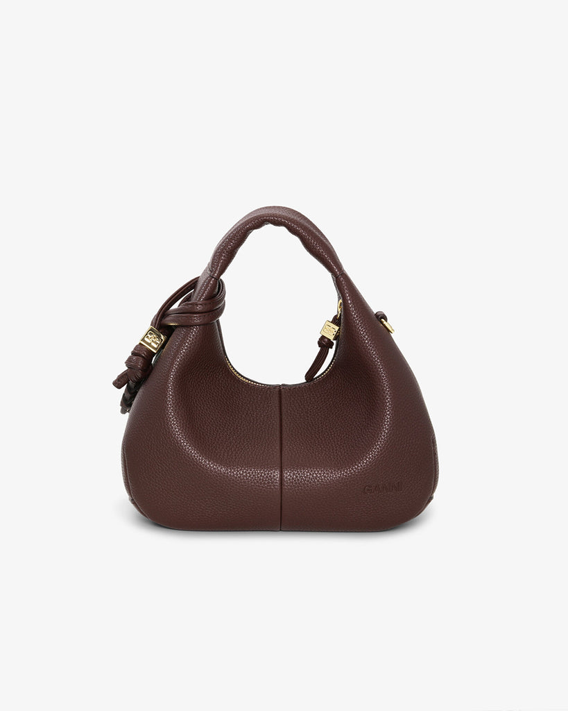 Mała, brązowa torebka w kształcie półksiężyca Hobo Mini Chicory Coffee z uchwytem i regulowanym, odpinanym paskiem oraz zapięciem na suwak. Z przodu posiada niewielki wypukły logotyp marki. Z tyłu, u dołu znajduje się wytłaczany napis GANNI. Do torebki dołączona jest lustrzana zawieszka. Wewnątrz posiada niewielką kieszonkę na najważniejsze drobiazgi takie jak klucze czy karta kredytowa.