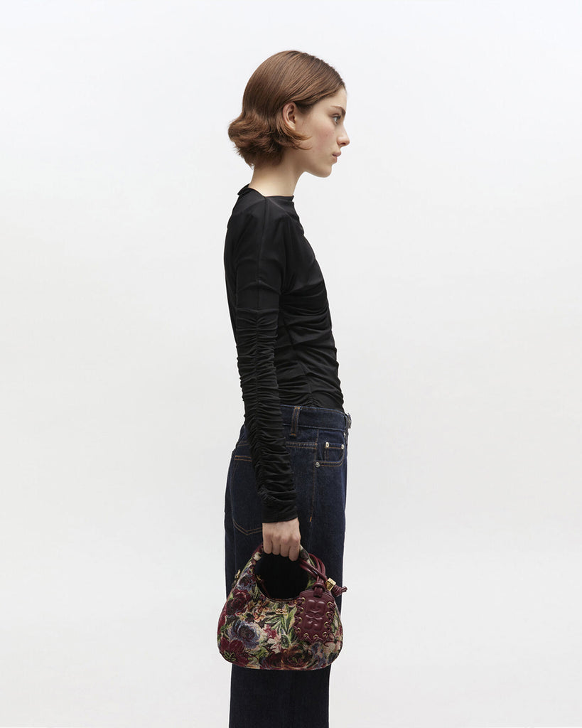 Mała torebka w kształcie półksiężyca Hobo Mini Tawny Port w kwiatowy print z uchwytem i regulowanym, odpinanym paskiem oraz zapięciem na suwak. Z przodu posiada niewielki wypukły logotyp marki. Z tyłu, u dołu znajduje się wytłaczany napis GANNI. Do torebki dołączona jest lustrzana zawieszka. Wewnątrz posiada niewielką kieszonkę na najważniejsze drobiazgi takie jak klucze czy karta kredytowa.&nbsp;