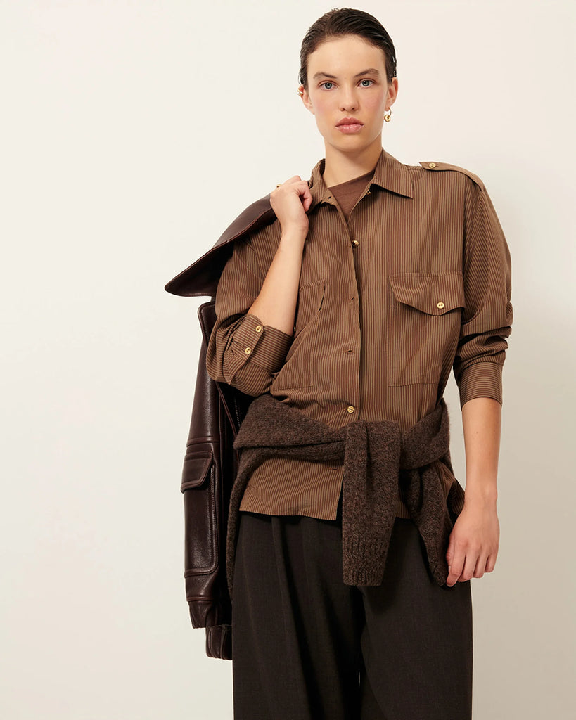 Efektowna koszula Honoria Nutsand francuskiej marki Sessun w oficerskim stylu, z długimi rękawami i paskami na ramionach z ozdobnymi guzikami.Na piersi naszywane ma kieszenie z patkami. Zapinana na ozdobne guziki. Wykonana z miękkiej, prążkowanej popeliny lyocell, tkanej we Włoszech.