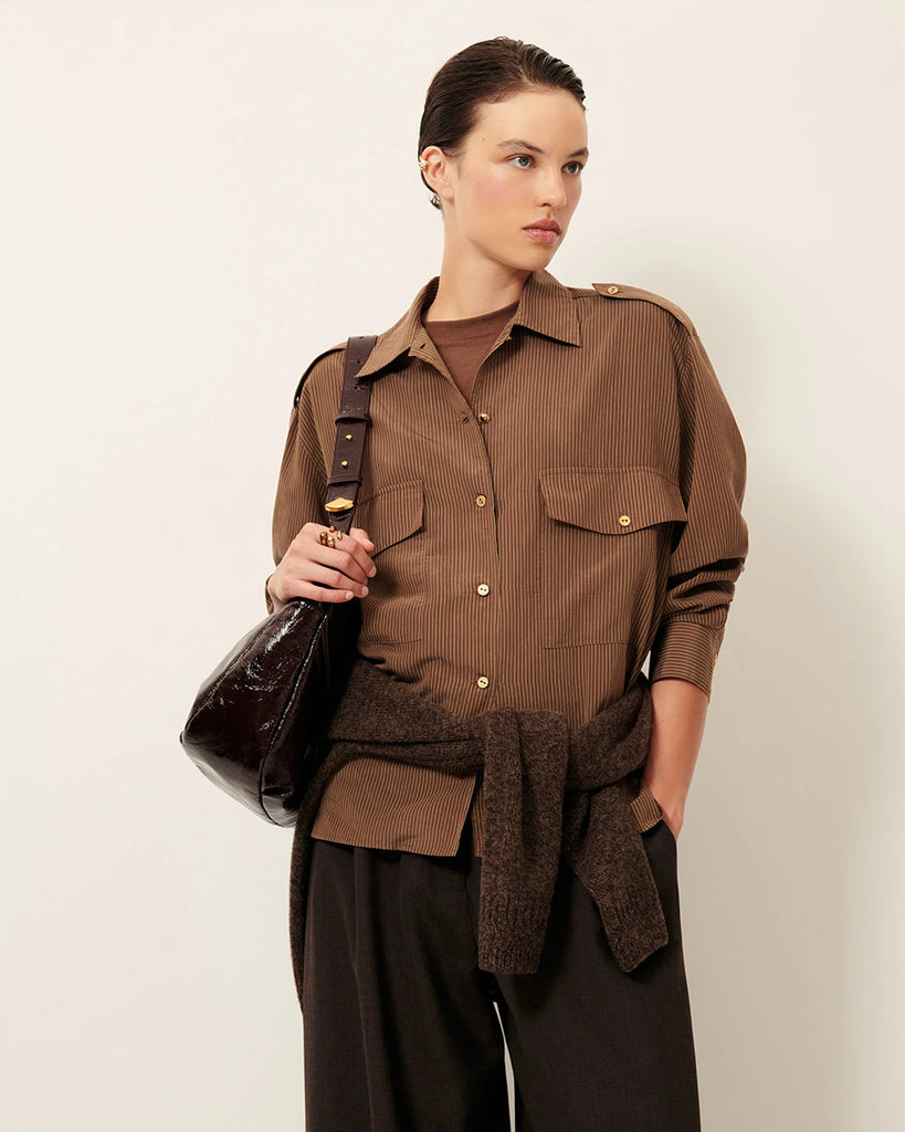 Efektowna koszula Honoria Nutsand francuskiej marki Sessun w oficerskim stylu, z długimi rękawami i paskami na ramionach z ozdobnymi guzikami.Na piersi naszywane ma kieszenie z patkami. Zapinana na ozdobne guziki. Wykonana z miękkiej, prążkowanej popeliny lyocell, tkanej we Włoszech.