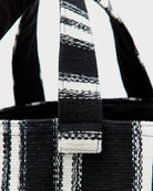 Gruba, tkana, bawełniana torba Ibox Stripe A marki Bellerose w czarno-białe paski. Bardzo pojemna w środku. Posiada solidne uchwyty, wewnętrzną kieszeń główną oraz mniejszą kieszeń z metką na imię. Na bocznym szwie widoczna jest niewielka etykieta z logo marki. Wykonana z grubej bawełny.&nbsp;