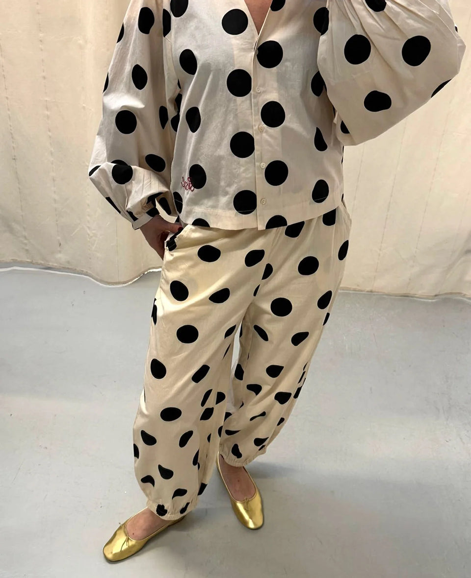 Luźne spodnie Iluna SISSEL EDELBO z żakardowej tkaniny z modnym wzorem polka dots. Posiadają szerokie, luźne nogawki zakończone wąskimi, elastycznymi ściągaczami. Spodnie mają elastyczną talię. Wykonane zostały z tkaniny pozyskanej z postprodukcji, co nadaje spodniom oryginalności i niepowtarzalności.

-Luźny fason

-Lekka tkanina w czarne grochy

-Ręcznie wykonane hafty&nbsp;

-Zamów spodnie w swoim normalnym rozmiarze