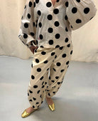 Luźne spodnie Iluna SISSEL EDELBO z żakardowej tkaniny z modnym wzorem polka dots. Posiadają szerokie, luźne nogawki zakończone wąskimi, elastycznymi ściągaczami. Spodnie mają elastyczną talię. Wykonane zostały z tkaniny pozyskanej z postprodukcji, co nadaje spodniom oryginalności i niepowtarzalności.

-Luźny fason

-Lekka tkanina w czarne grochy

-Ręcznie wykonane hafty&nbsp;

-Zamów spodnie w swoim normalnym rozmiarze