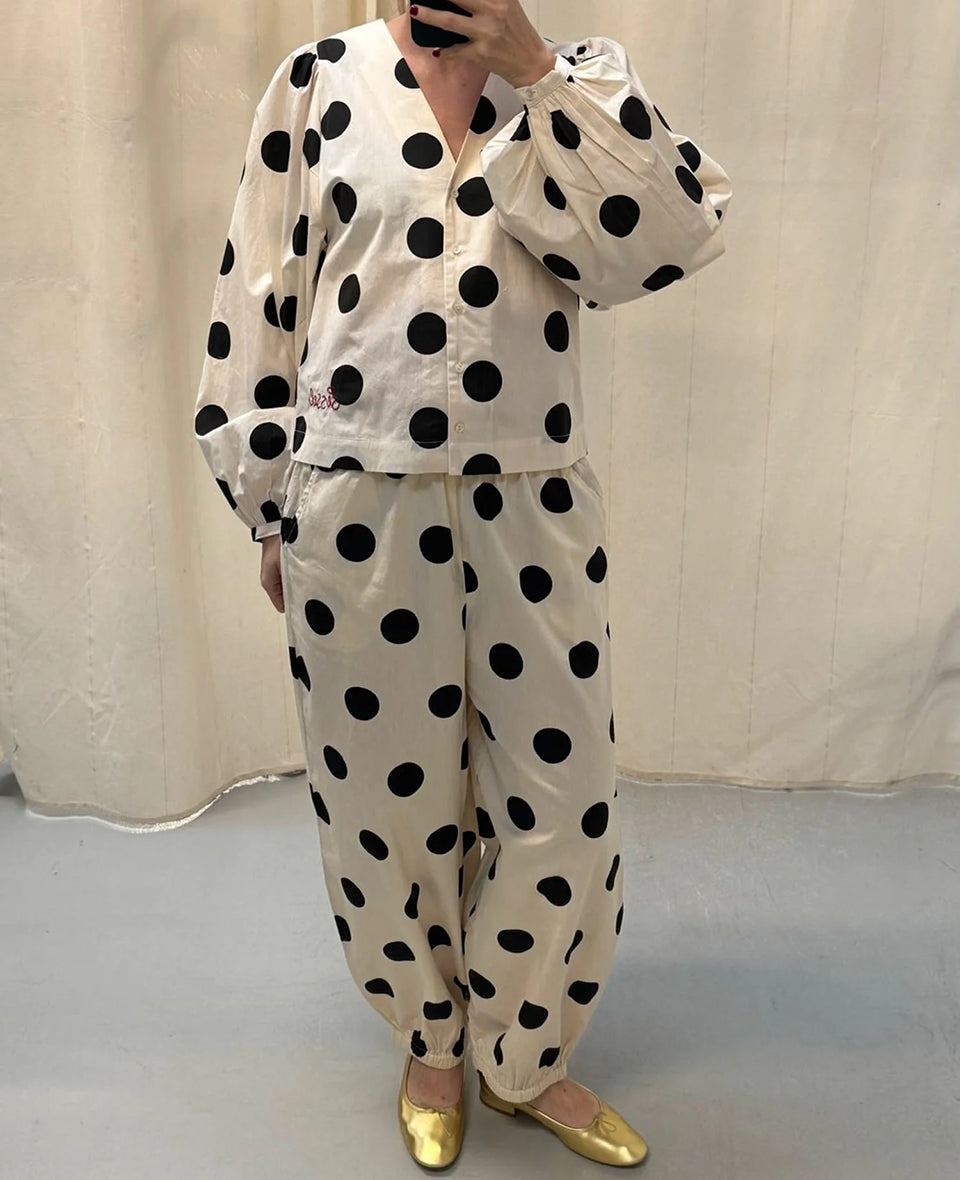 Luźne spodnie Iluna SISSEL EDELBO z żakardowej tkaniny z modnym wzorem polka dots. Posiadają szerokie, luźne nogawki zakończone wąskimi, elastycznymi ściągaczami. Spodnie mają elastyczną talię. Wykonane zostały z tkaniny pozyskanej z postprodukcji, co nadaje spodniom oryginalności i niepowtarzalności.

-Luźny fason

-Lekka tkanina w czarne grochy

-Ręcznie wykonane hafty&nbsp;

-Zamów spodnie w swoim normalnym rozmiarze