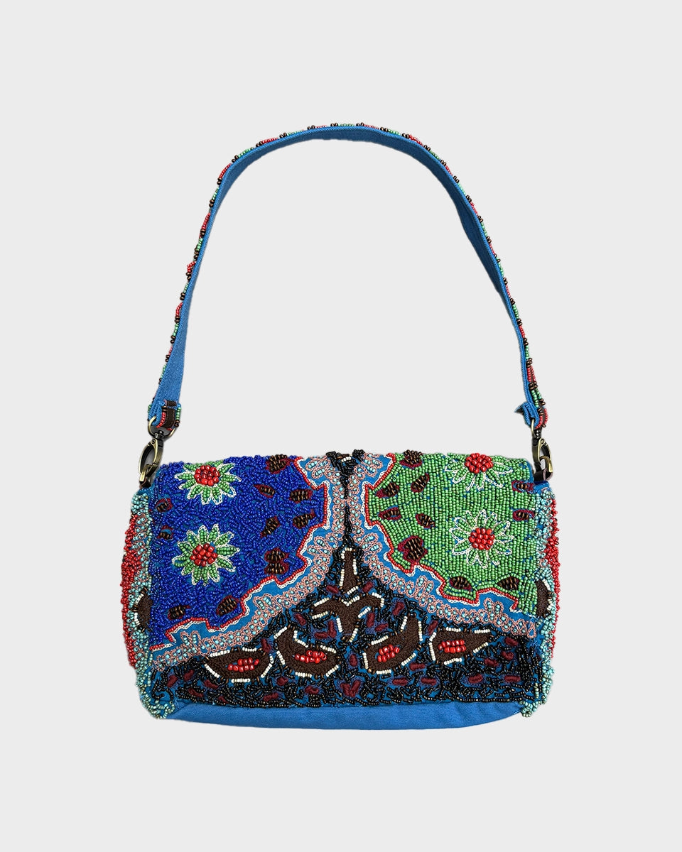 Ręcznie wykonana torebka bagietka Naxos Imayin wyszyta ręcznie drobnymi, kolorowymi koralikami. Zamykana na klapkę i magnes. Wewnątrz torebki znajduje się pasek z karabińczykiem, do którego można przypiąć klucze oraz się dwie kieszonki na najważniejsze drobiazgi. Jedna z nich zapinana jest na zamek błyskawiczny. Posiada dwa, odpinane paski - jeden płócienny, wyszywany koralikami do zawieszenia na ramieniu i drugi, skórzany, dłuższy i o regulowanej długości do zawieszenia przez ramię.