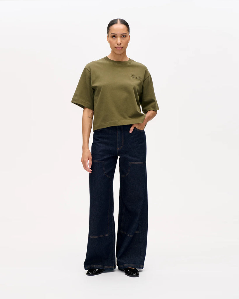 Luźny t-shirt Jiana Ivy Green w kolorze zielonym z okrągłym dekoltem i obniżonymi ramionami. Na prawej piersi wytłoczone jest logo marki. Wykonany z miękkiej, grubej bawełny organicznej. Idealnie pasuje do klasycznych jeansów lub spodni.