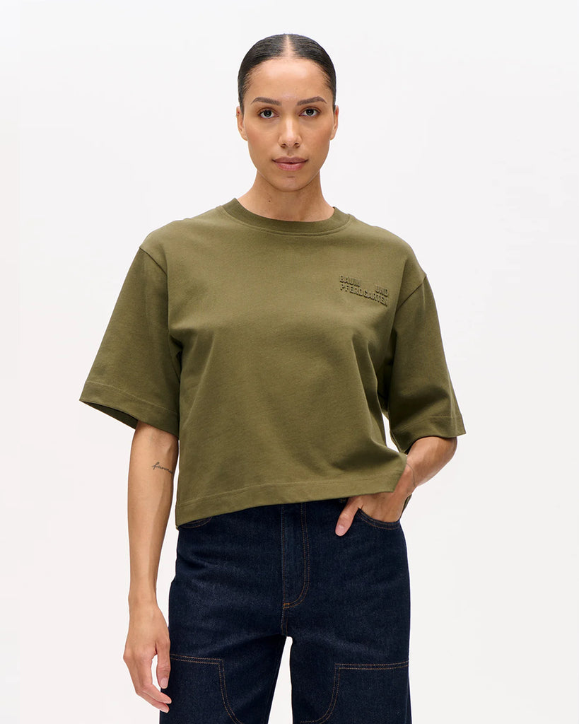 Luźny t-shirt Jiana Ivy Green w kolorze zielonym z okrągłym dekoltem i obniżonymi ramionami. Na prawej piersi wytłoczone jest logo marki. Wykonany z miękkiej, grubej bawełny organicznej. Idealnie pasuje do klasycznych jeansów lub spodni.