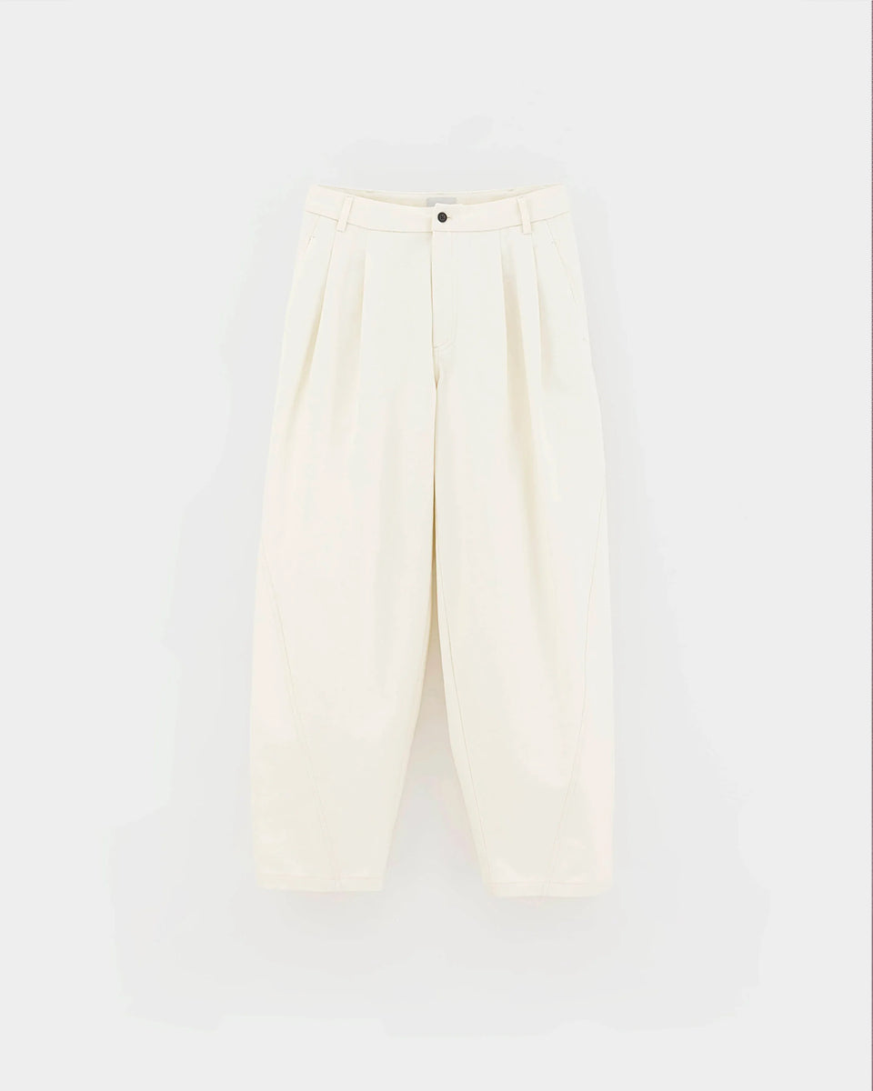 Eleganckie spodnie w kolorze ecru Jimi Natural marki Bellerose wykonane ze szczotkowanego diagonalu bawełnianego. Wyróżniają się zakładkami z przodu oraz swobodnym krojem ze zwężanymi nogawkami, a subtelnie przesunięte szwy boczne nadają im nowoczesny, wyrazisty charakter. Posiadają zapięcie na zamek, szlufki na pasek i kieszenie w szwach bocznych oraz wpuszczane kieszenie tylne.&nbsp;

-Elegancki, luźny krój

-Zwężane nogawki

-Zamów spodnie w swoim standardowym rozmiarze&nbsp;