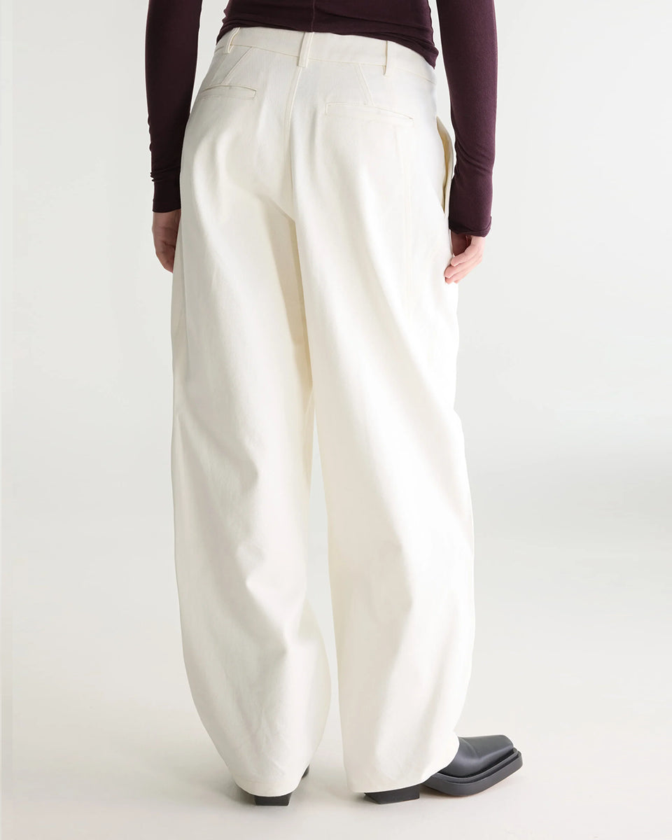 Eleganckie spodnie w kolorze ecru Jimi Natural marki Bellerose wykonane ze szczotkowanego diagonalu bawełnianego. Wyróżniają się zakładkami z przodu oraz swobodnym krojem ze zwężanymi nogawkami, a subtelnie przesunięte szwy boczne nadają im nowoczesny, wyrazisty charakter. Posiadają zapięcie na zamek, szlufki na pasek i kieszenie w szwach bocznych oraz wpuszczane kieszenie tylne.&nbsp;

-Elegancki, luźny krój

-Zwężane nogawki

-Zamów spodnie w swoim standardowym rozmiarze&nbsp;