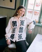 Klasyczna, bawełniana koszula Kaiser Off White marki SISSEL EDELBO z kołnierzykiem i długimi rękawami, które zakończone są mankietami ze zdobieniami w kształcie serc. Zapinana na jasne guziki wykonane z masy perłowej. Wzdłuż plisy biegnie delikatna falbanka, a szwy na ramionach są lekko przesunięte do przodu. Koszulę zdobi piękny haft umieszony na przodzie i rękawach. Wykonana jest z miękkiej, podwójnej gazy ze 100% bawełny organicznej.&nbsp;

-Klasyczny, koszulowy fason

-Ozdobne hafty

-100% bawełna organ