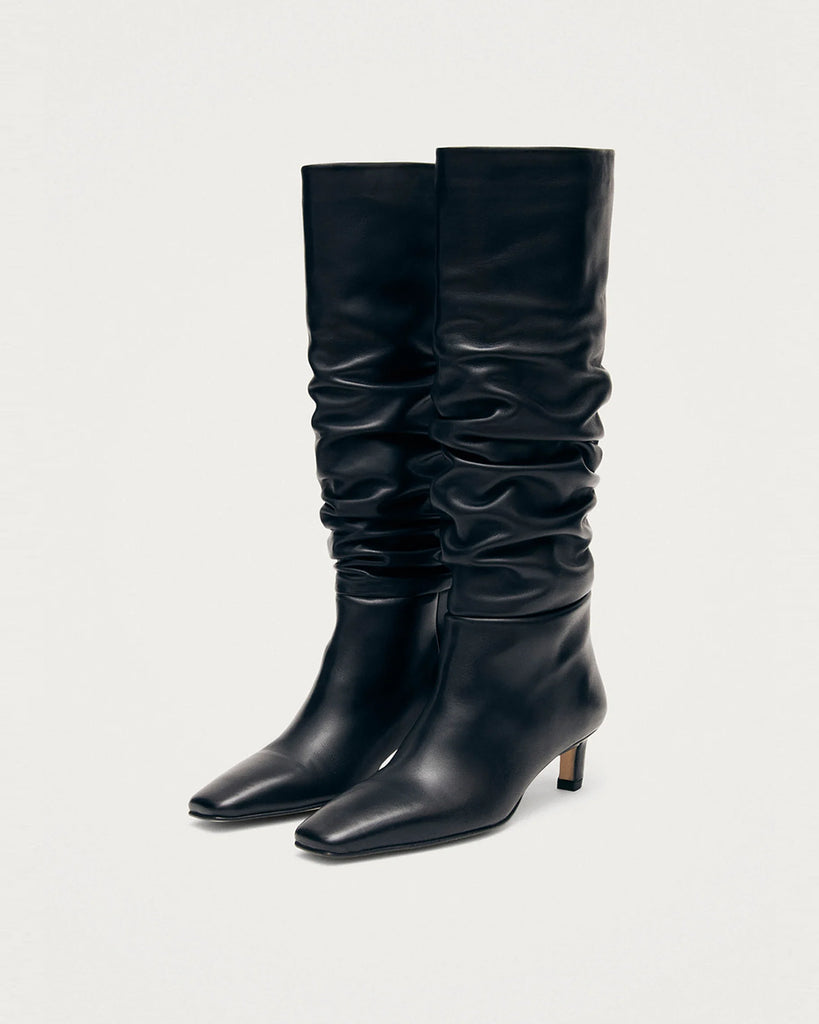 Czarne Kozaki ALOHAS Kalila Black Leather na obcasie typu kaczuszek. Kozaki do kolan wykonane z czarnej skóry z wydłużonymi, kwadratowymi noskami i niskim obcasem, który zapewnia wygodę. Efektowne marszczenia na cholewce dodają im charakteru, który przyciągnie uwagę każdej stylizacji.&nbsp;