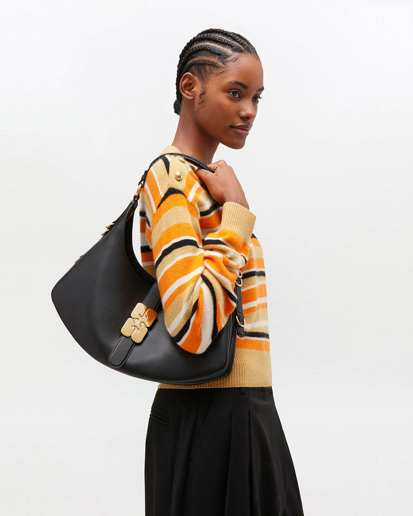 Ponadczasowa, czarna torebka Kat Small 6998 GANNI black w stylu souffle o zaokrąglonym kształcie, z paskiem na ramię i detalami w kształcie D-ringów z boku. Posiada zapięcie z przodu, z charakterystycznym złotym detalem GANNI Butterfly. Ma jedną, główną kieszeń otwartą. Wykonana z opatentowanego przez markę, ekologicznego materiału bedącego połączeniem skóry z recyclingu oraz syntetycznych włókien. Uniwersalny rozmiar torebki sprawia, że będzie idealna zarówno na codzień, jak i na eleganckie okazje.&nbsp;