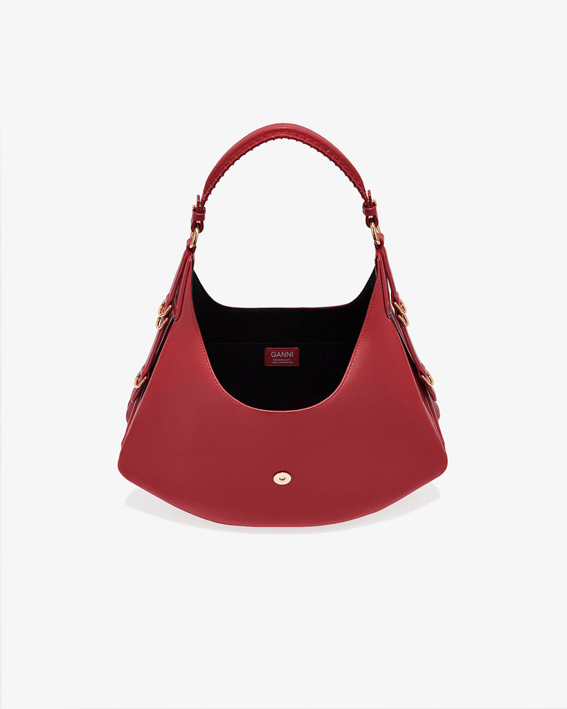 Ponadczasowa, czerwona torebka Kat Small 7077 GANNI Red Dahlia w stylu souffle o zaokrąglonym kształcie, z paskiem na ramię i detalami w kształcie D-ringów z boku. Posiada zapięcie z przodu, z charakterystycznym złotym detalem GANNI Butterfly. Ma jedną, główną kieszeń otwartą. Wykonana z opatentowanego przez markę, ekologicznego materiału bedącego połączeniem skóry z recyclingu oraz syntetycznych włókien. Uniwersalny rozmiar torebki sprawia, że będzie idealna zarówno na codzień, jak i na eleganckie okazje.&