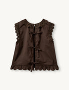 Swobodny, bawełniany top Kirsten Cloth Chocolate marki The Garment o lekko trapezowym kształcie. Ma okrągły dekolt wykończony szerokim, koronkowym kołnierzykiem. Podobne obszycia znajdują się wokół ramion, co tworzy efekt falbanki. Na piersi widoczny jest subtelny, ażurowy haft. Plecy są rozcięte i wiązane na trzy kokardki. Dół wykończony jest falistym brzegiem.

-Ażurowe hafty

-Tył wiązany na kokardki

-Bawełna organiczna

-Zamów top w swoim standardowym rozmiarze