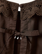 Swobodny, bawełniany top Kirsten Cloth Chocolate marki The Garment o lekko trapezowym kształcie. Ma okrągły dekolt wykończony szerokim, koronkowym kołnierzykiem. Podobne obszycia znajdują się wokół ramion, co tworzy efekt falbanki. Na piersi widoczny jest subtelny, ażurowy haft. Plecy są rozcięte i wiązane na trzy kokardki. Dół wykończony jest falistym brzegiem.

-Ażurowe hafty

-Tył wiązany na kokardki

-Bawełna organiczna

-Zamów top w swoim standardowym rozmiarze