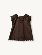 Swobodny, bawełniany top Kirsten Cloth Chocolate marki The Garment o lekko trapezowym kształcie. Ma okrągły dekolt wykończony szerokim, koronkowym kołnierzykiem. Podobne obszycia znajdują się wokół ramion, co tworzy efekt falbanki. Na piersi widoczny jest subtelny, ażurowy haft. Plecy są rozcięte i wiązane na trzy kokardki. Dół wykończony jest falistym brzegiem.

-Ażurowe hafty

-Tył wiązany na kokardki

-Bawełna organiczna

-Zamów top w swoim standardowym rozmiarze