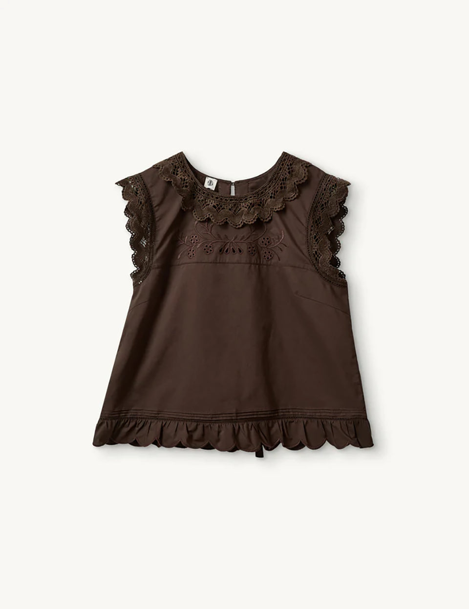 Swobodny, bawełniany top Kirsten Cloth Chocolate marki The Garment o lekko trapezowym kształcie. Ma okrągły dekolt wykończony szerokim, koronkowym kołnierzykiem. Podobne obszycia znajdują się wokół ramion, co tworzy efekt falbanki. Na piersi widoczny jest subtelny, ażurowy haft. Plecy są rozcięte i wiązane na trzy kokardki. Dół wykończony jest falistym brzegiem.

-Ażurowe hafty

-Tył wiązany na kokardki

-Bawełna organiczna

-Zamów top w swoim standardowym rozmiarze