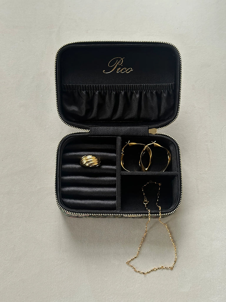 Kuferek do przechowywania biżuterii Pico Copenhagen z przegródkami wewnątrz. Obszyty tkaniną imitującą jeans. Zapinany za pomocą zamka błyskawicznego. To idealny pomysł na prezent.&nbsp;