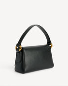 Minimalistyczna, elegancka torebka Lellie Black By Malene Birger o prostokątnym kształcie z lekko zaokrąglonymi bokami. Zapinana na zatrzask magnetyczny. Posiada krótki, szeroki pasek na ramię, który ozdobiony jest złotymi elementami. Na środku klapy umieszczono metalowy emblemat marki w kolorze złotym. W środku znajduje się mała kieszonka na drobiazgi, a całość wykończona jest gładką podszewką. Wykonana w 100% ze skóry.&nbsp;