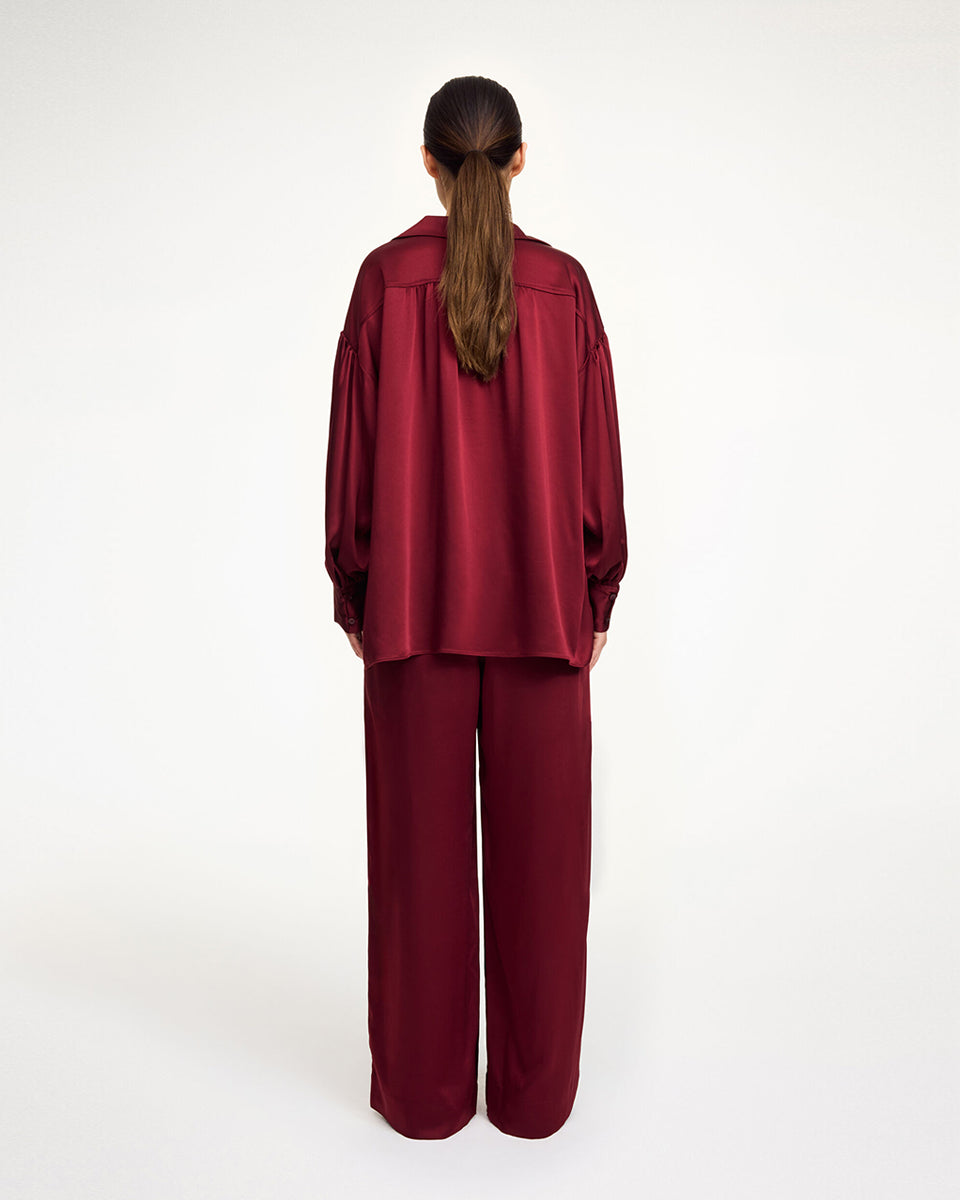 Efektowna, romantyczna bluzka Leonora Satin Cabernet By Malene Birger z kołnierzykiem, dekoltem w kształcie litery V i długimi, lekko bufiastymi rękawami z marszczeniami przy ramionach. Dodatkowo rękawy zakończone są mankietami zapinanymi na guziki. Wykonana z gładkiej, lekko połyskującej tkaniny o satynowym wykończeniu. Bluzka sprawdzi się zarówno w eleganckich, jak i bardziej codziennych stylizacjach.&nbsp;

-Zawyżona rozmiarówka. Zalecamy wybór mniejszego rozmiaru.