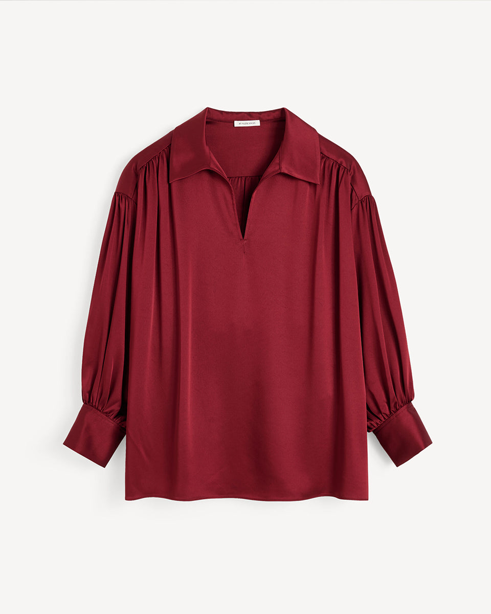 Efektowna, romantyczna bluzka Leonora Satin Cabernet By Malene Birger z kołnierzykiem, dekoltem w kształcie litery V i długimi, lekko bufiastymi rękawami z marszczeniami przy ramionach. Dodatkowo rękawy zakończone są mankietami zapinanymi na guziki. Wykonana z gładkiej, lekko połyskującej tkaniny o satynowym wykończeniu. Bluzka sprawdzi się zarówno w eleganckich, jak i bardziej codziennych stylizacjach.&nbsp;

-Zawyżona rozmiarówka. Zalecamy wybór mniejszego rozmiaru.