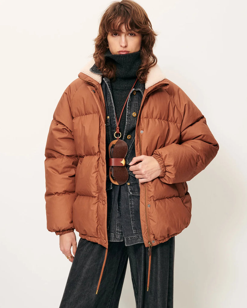 Oversizowa, puchowa kurtka Livingstone Azelan francuskiej marki Sessun z wysokim kołnierzem podszytym sztuczną owczą skórą. Ma raglanowe rękawy, ściągacz u dołu i dwie kieszenie z przodu. Zapinana na kryty zamek błyskawiczny. Wykonana z kompaktowej, pikowanej, wodoodpornej bawełny wypełnionej pierzem z certyfikowanego, naturalnego pochodzenia.

-Oversizowy krój

-Raglanowe rękawy i wysoki kołnierz&nbsp;

-Zamów w rozmiarze, który zazwyczaj nosisz